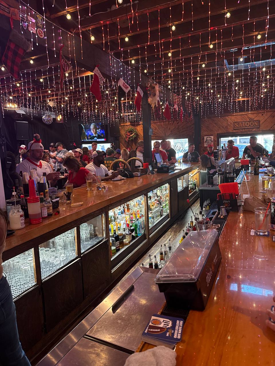 Guests filling the bar beneath the lights at The Hermosa Saloon