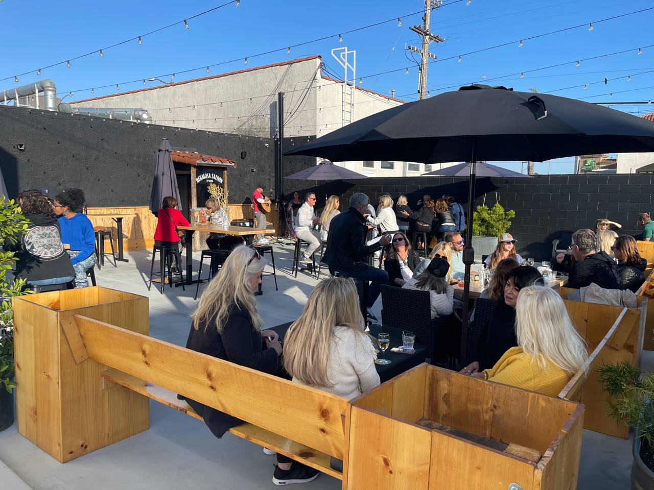 Guests enjoying a sunny afternoon gathering on The Hermosa Saloon patio